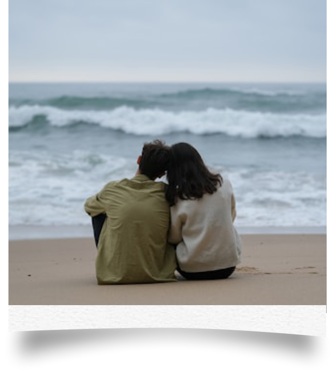 A photo note of a couple sitting together by the ocean, on the app’s textured sticky paper